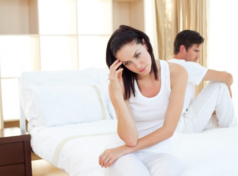 Upset couple finding out results of a pregnancy test in the bedroom